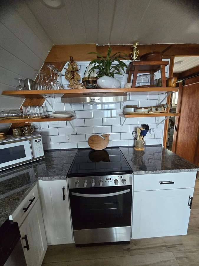 A-frame kitchen with wood shelving and white tile