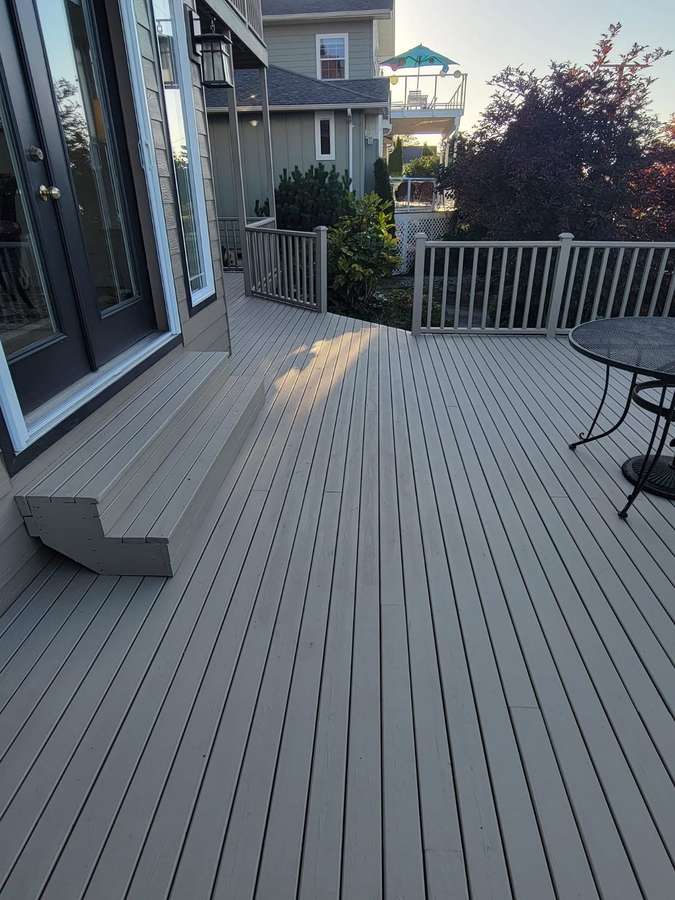 A deck 3B's Home Repair rebuilt, with new railings and a view over the trees in Blaine