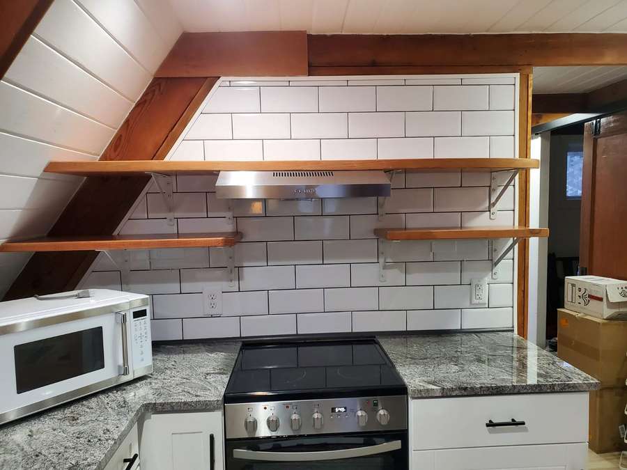 Kitchen with white subway tile backsplash and open shelving