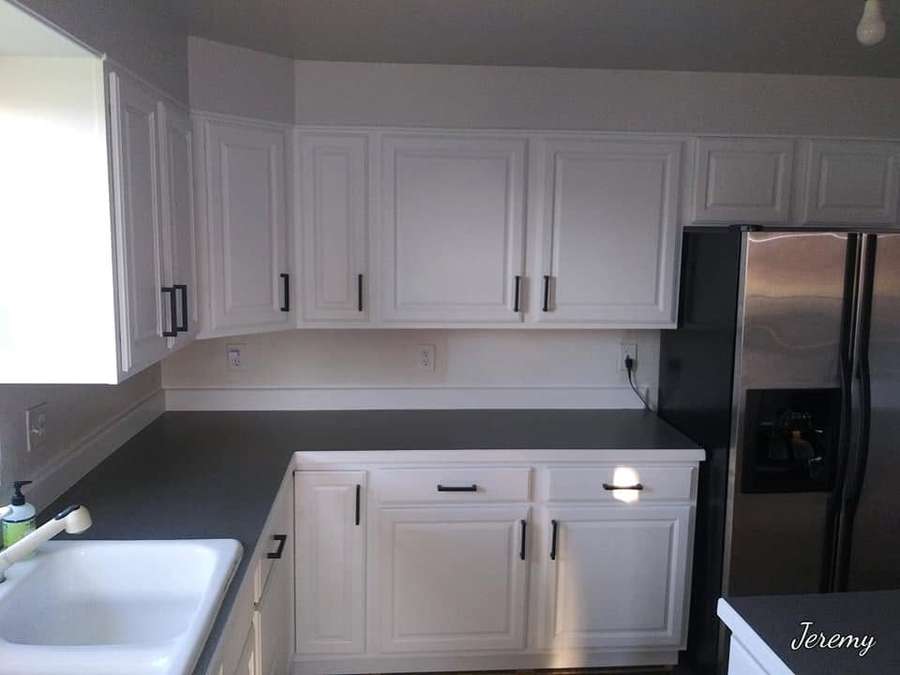 Bright kitchen with white cabinets and dark countertops